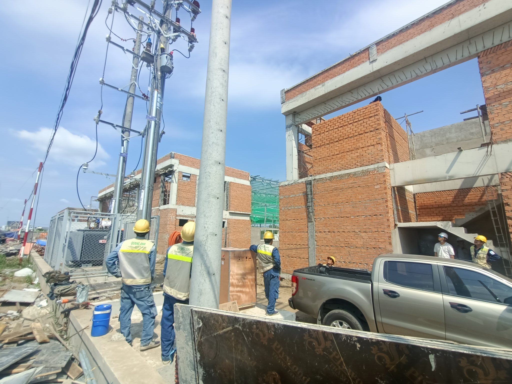 QuangAnhcons và các lĩnh vực chuyên môn. Công nhân đang lắp đặt hệ thống điện cho công trình công nghiệp hiện đại.